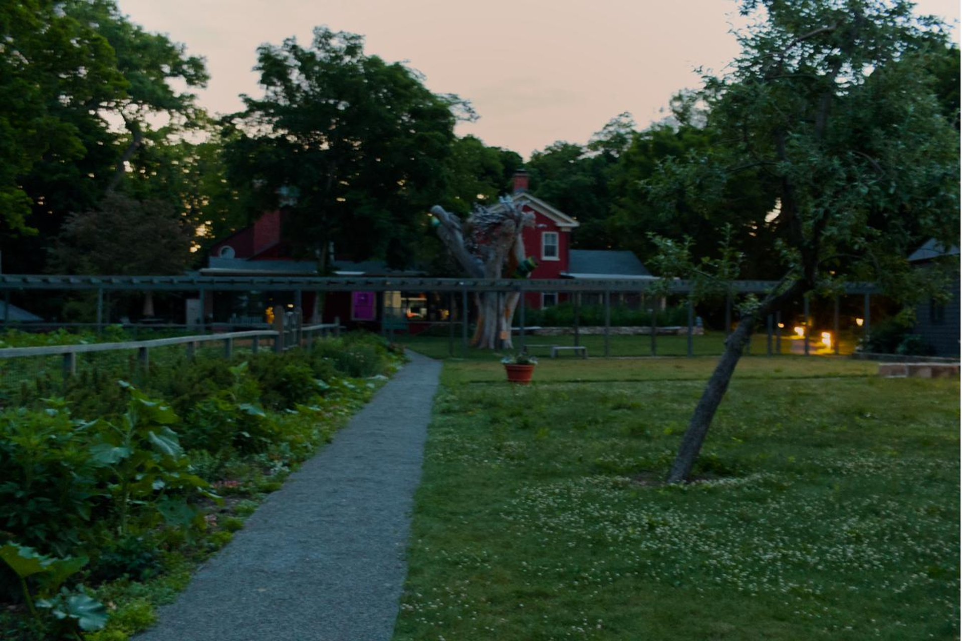 Garden path at dusk leading to the red farmhouse